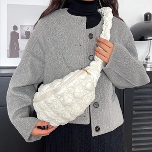 Détail d'un sac bandoulière matelassé blanc montrant la texture douce et la forme en croissant