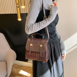 Détail d'un sac d'hiver combinant cuir marron et texture en laine à carreaux classique