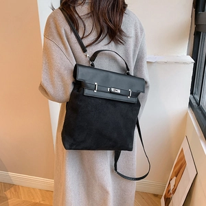 Detail of minimalist black PU and suede shoulder bag with classic metal twist lock buckle