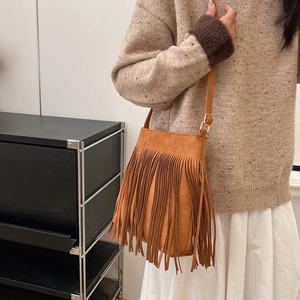 Λεπτομέρεια boho καφέ σουέτ τσάντας με μακριά κρόσσια και χρυσή μεταλλική αγκράφα