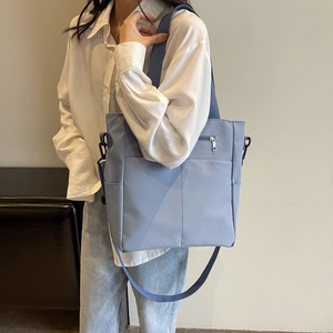 Sac bandoulière bleu clair imperméable porté par un mannequin dans une pièce