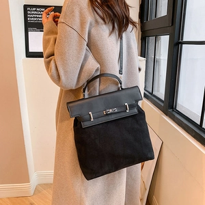 Black PU and suede拼接 material handbag styled on a model in a bright minimalist setting