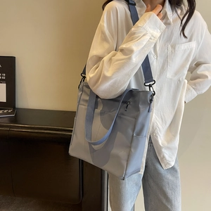 Détail du sac fourre-tout en nylon bleu clair imperméable avec poche latérale et bandoulière