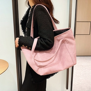 Pink oversized matte tote bag in textured canvas fabric worn with a black jacket