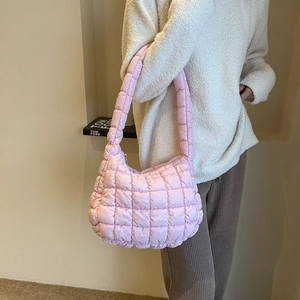 Gros plan détaillé d'un sac à bandoulière matelassé rose avec une texture douce et large bandoulière