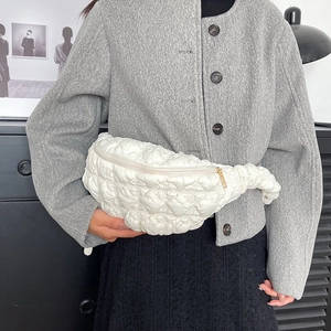 Vue détaillée d'un sac bandoulière matelassé blanc montrant la texture et la fermeture éclair