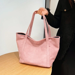 Detail of pink suede tote bag with front pocket showing soft texture and large capacity