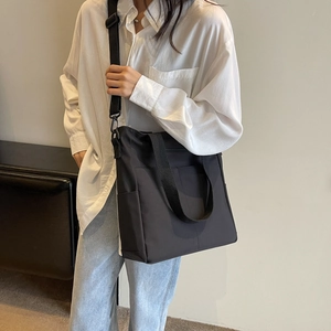 Sac fourre-tout en nylon noir imperméable porté par un mannequin pour le bureau