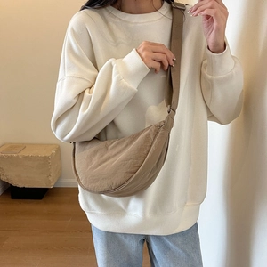 Brown nylon crescent bag shown on model with adjustable wide strap and minimalist style