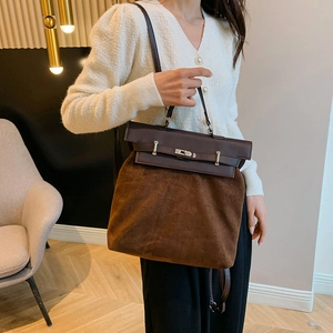 Detail of premium brown suede and leather handbag with silver metallic turn-lock closure
