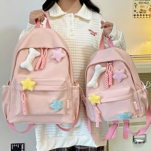 Comparaison de sacs à dos en nylon rose en deux tailles avec des breloques décoratives