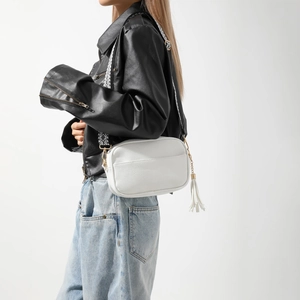 Détail du sac à bandoulière en cuir grainé blanc avec frange et sangle tissée