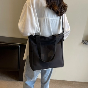 Détail du grand sac cabas noir en nylon montrant la poche latérale et la bandoulière