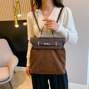 Detail of coffee-colored faux suede handbag with smooth leather strap and metal twist lock