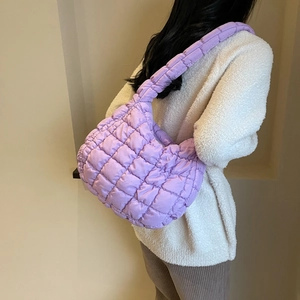 Vue arrière d'un sac bandoulière matelassé lavande porté par un mannequin en intérieur