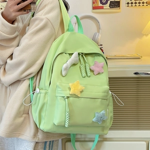 Détail d'un sac à dos en nylon vert clair avec étoiles en peluche et poches pratiques