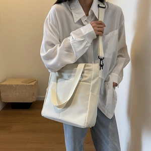 Sac fourre-tout blanc imperméable avec bandoulière réglable porté par un mannequin