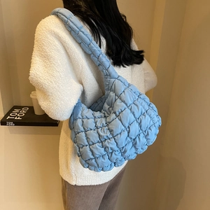 Détail du sac hobo matelassé bleu clair montrant la texture du tissu rembourré
