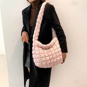 Detail view of pink quilted puffer shoulder bag showing soft padded material texture