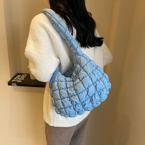 Détail de la vue arrière d'un sac bouffant bleu ciel matelassé en tissu texturé