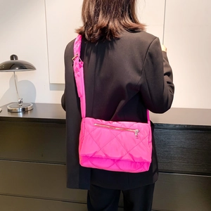 Dettaglio borsa a tracolla in nylon trapuntato rosa acceso con ampia tracolla e zip metallica