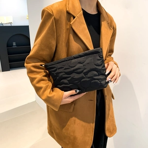 Detail of premium black quilted handbag with wavy stitching pattern and soft texture