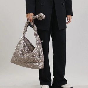 Detail of metallic quilted tote bag with heart stitching and ruched handle design