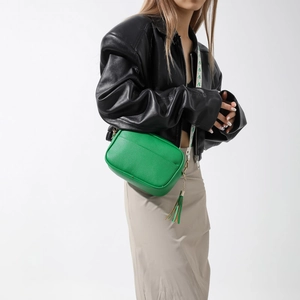 Sac à bandoulière chic en PU vert avec pompon et sangle imprimée porté par un mannequin cuir