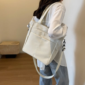Détail du sac bandoulière imperméable blanc cassé avec poches avant et sangle