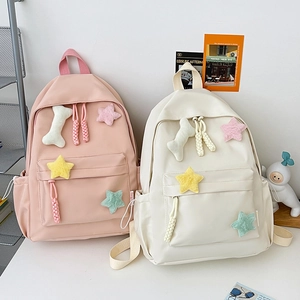 Détail du sac à dos en nylon avec pendentifs étoiles en peluche et zips tressés