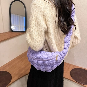 Détail d'un sac bandoulière violet matelassé avec texture bulle et fermeture éclair dorée