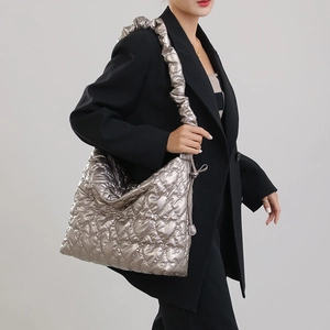 Close-up of metallic silver quilted tote bag with heart patterns and ruched wide strap