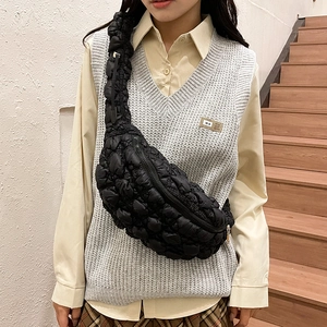 Sac croissant noir matelassé porté par un mannequin avec texture bouffante élégante