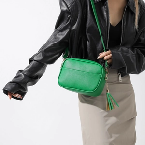 Détail du sac bandoulière vert vif en cuir grainé avec élégant pendentif à pampilles