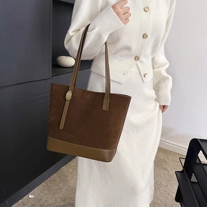 Détail du grand sac cabas marron foncé avec texture en daim et boucle dorée sur l'anse