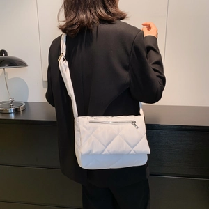 Dettaglio della borsa a tracolla bianca trapuntata con cuciture a rombi e zip argento