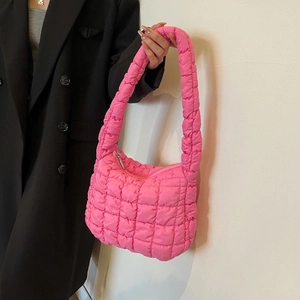 Gros plan détaillé de la texture matelassée et de la finition en tissu du sac rose