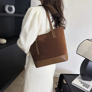 Détail du sac fourre-tout en patchwork de cuir et daim marron avec fermeture éclair dorée