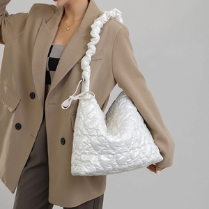 Detail of white quilted nylon shoulder bag with heart pattern and scrunchie strap design