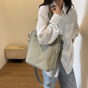 Gros plan du sac fourre-tout vert clair imperméable avec deux poches et bandoulière large