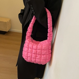 Gros plan d'un sac à bandoulière matelassé rose vif avec une texture en nylon brillant