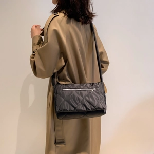 Dettaglio della borsa a tracolla trapuntata in nylon nero con cerniera argento