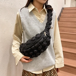 Détail du sac matelassé noir avec texture à bulles et design en forme de croissant