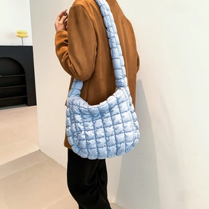 Close-up of light blue quilted crossbody bag featuring soft textured bubble fabric