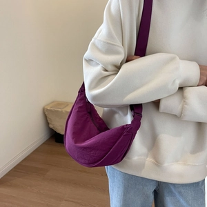 Detail of purple crescent nylon crossbody bag with adjustable strap and textured fabric