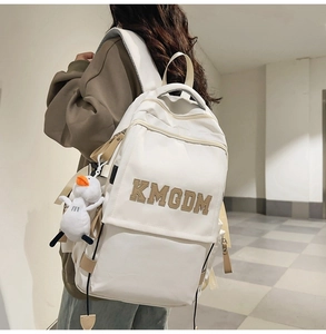 Detail of off-white nylon backpack with KMGDM embroidery and cute duck plush charm
