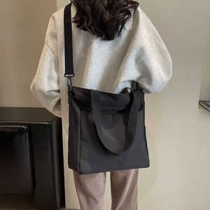 Vue détaillée du sac fourre-tout noir imperméable avec bandoulière amovible