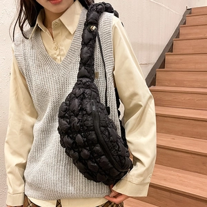 Gros plan du sac bandoulière matelassé noir avec texture 3D à bulles et design demi-lune