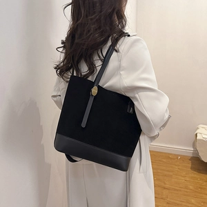 Détail du sac cabas noir en patchwork de daim et cuir avec des accents métalliques dorés