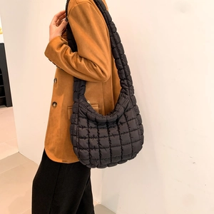 Close-up of black quilted puffer shoulder bag featuring lightweight nylon and puffy texture